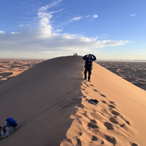 Trekkeurs au sommet d'une dune de l'Erg Chegaga