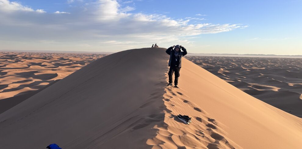 Trekkeurs au sommet d'une dune de l'Erg Chegaga
