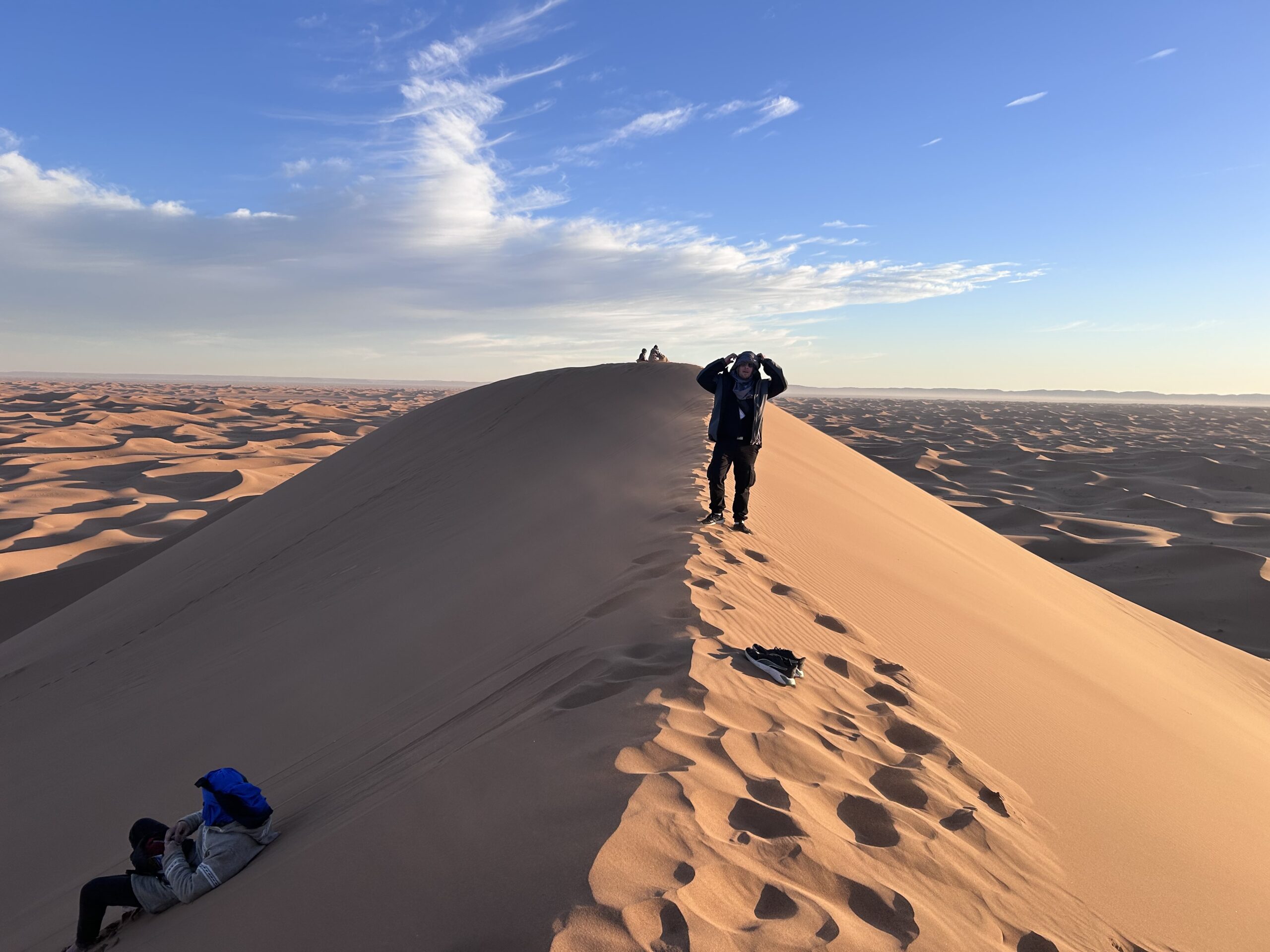 Trekkeurs au sommet d'une dune de l'Erg Chegaga
