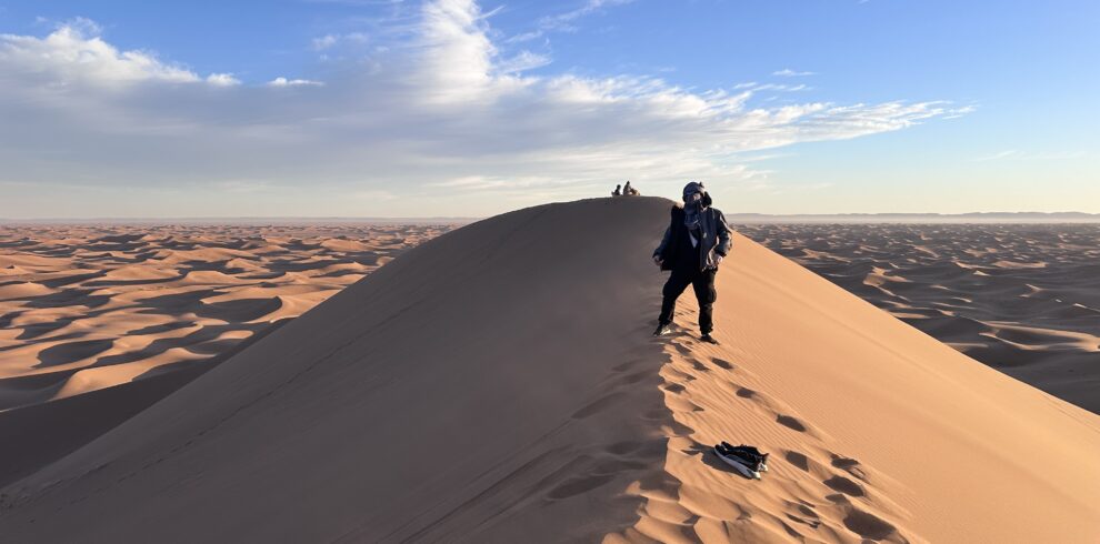 Groupe de voyageurs sur une crête de dune au lever du soleil