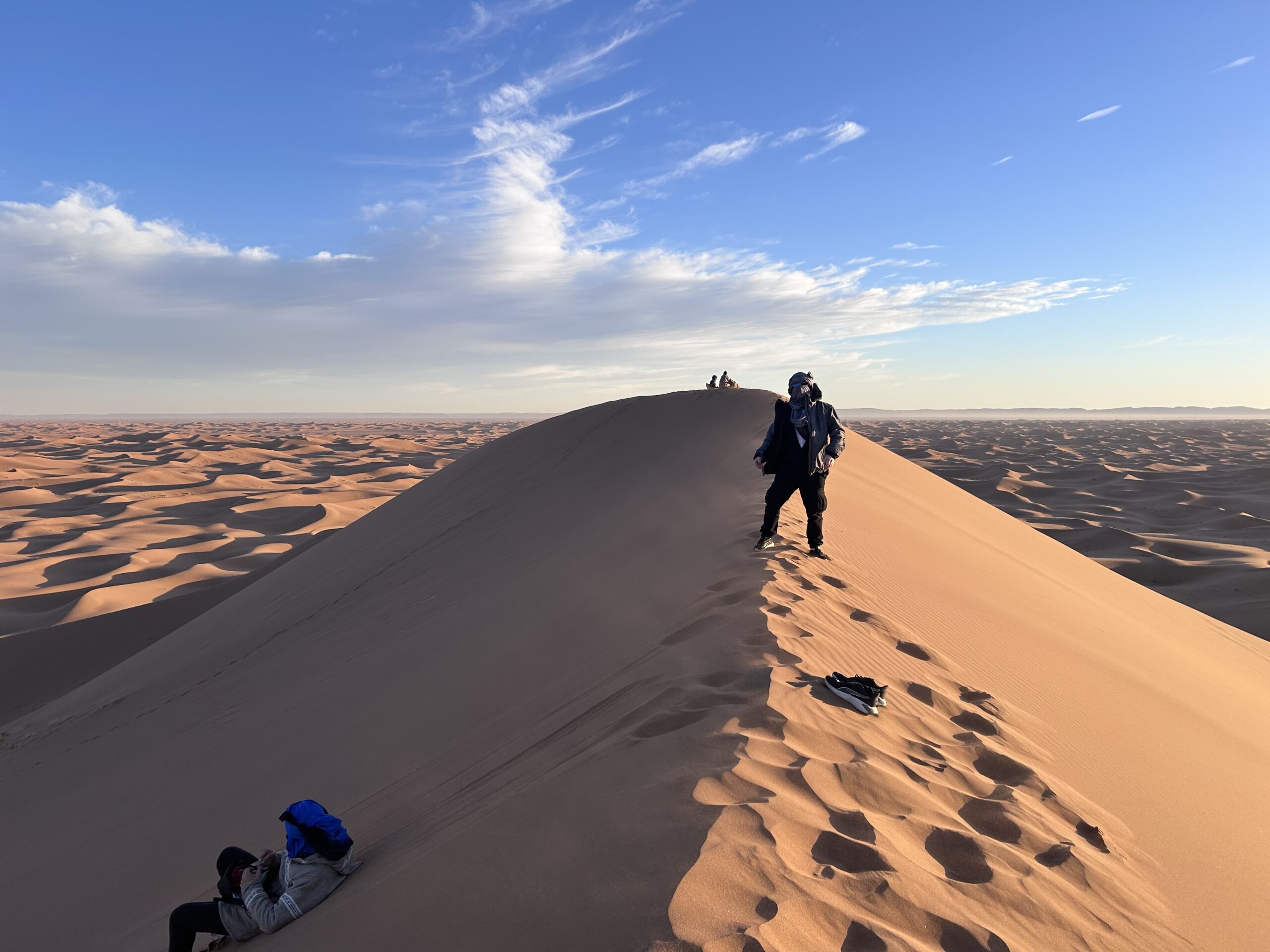 Groupe de voyageurs sur une crête de dune au lever du soleil