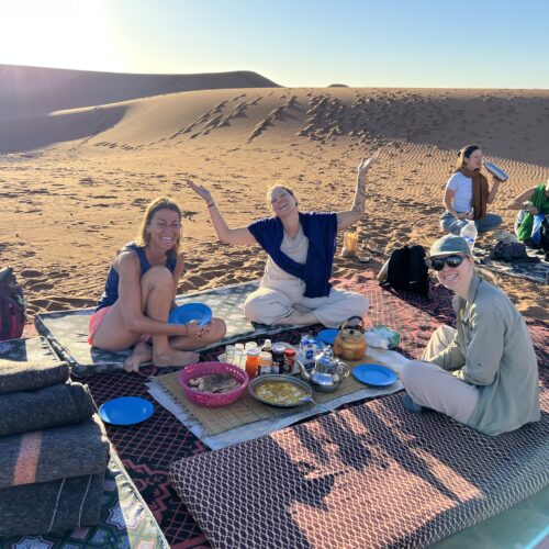 Petit-déjeuner en groupe dans le désert marocain, ambiance conviviale