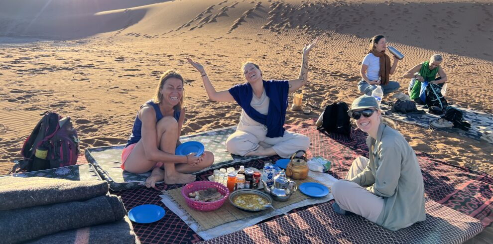 Petit-déjeuner en groupe dans le désert marocain, ambiance conviviale