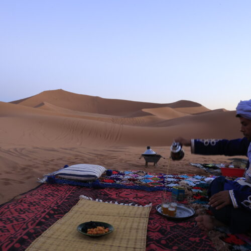 Thé traditionnel berbère au coucher du soleil, bivouac dans le désert
