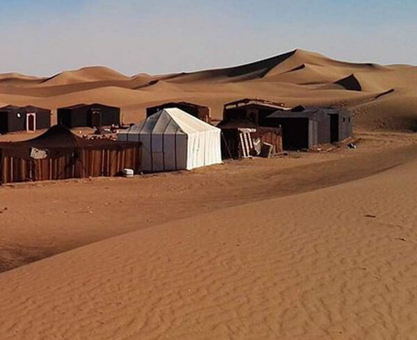 Camp sauvage berbère à l'Erg Zahar sous un ciel étoilé, désert marocain